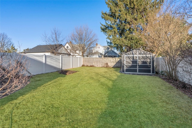 view of yard featuring an outbuilding, a fenced backyard, and a shed