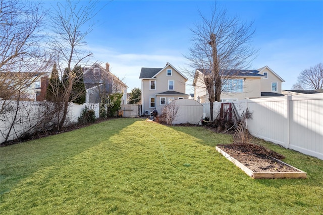 view of yard with a vegetable garden and a fenced backyard