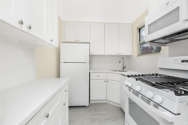 kitchen with white cabinets, white appliances, light countertops, and a sink