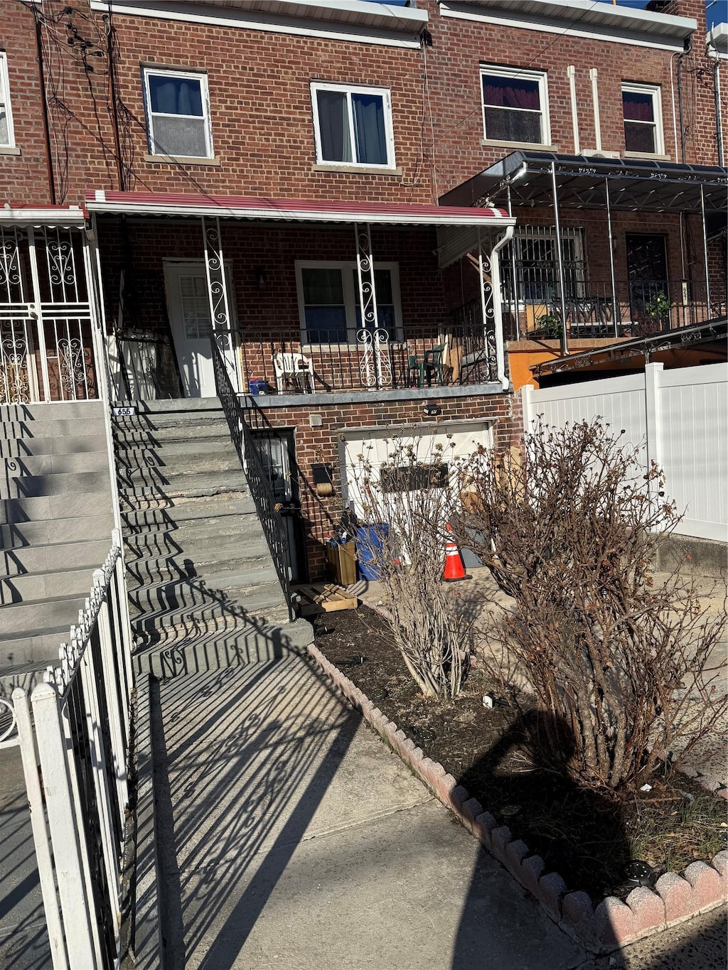 view of front of home with brick siding, covered porch, and stairs