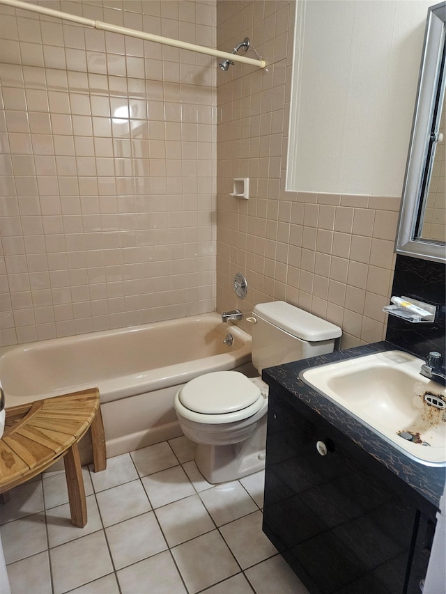 full bathroom featuring tile walls, toilet, tile patterned floors, washtub / shower combination, and a sink