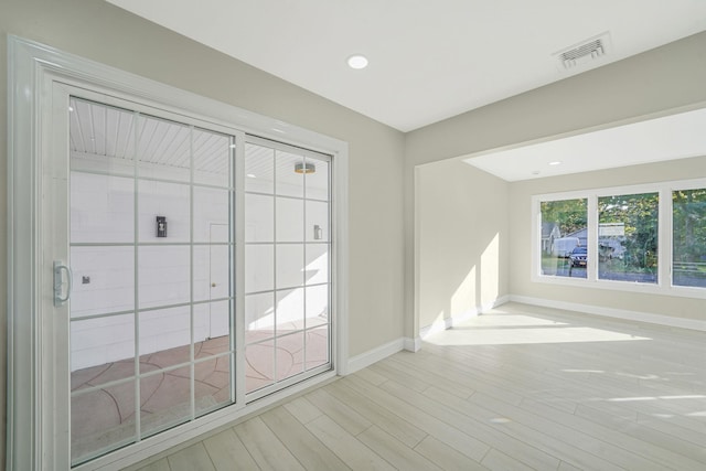 empty room featuring recessed lighting, visible vents, baseboards, and wood finished floors