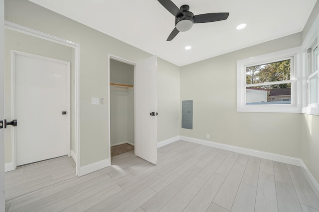 unfurnished bedroom with electric panel, recessed lighting, baseboards, and light wood-style floors