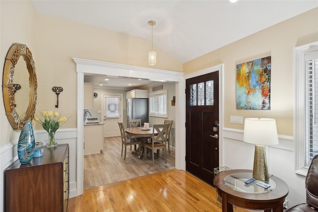 entryway featuring lofted ceiling and light wood-style flooring