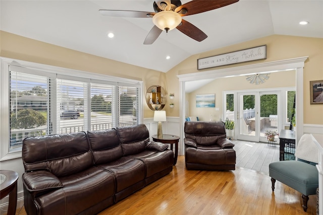 living area with french doors, light wood finished floors, wainscoting, and vaulted ceiling