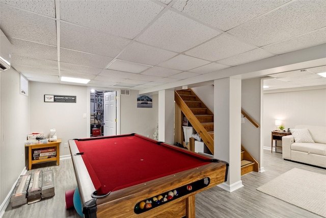 rec room with a drop ceiling, baseboards, visible vents, and wood finished floors