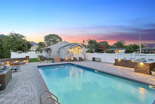 view of pool featuring a fenced in pool, entry steps, exterior kitchen, a fenced backyard, and a patio area