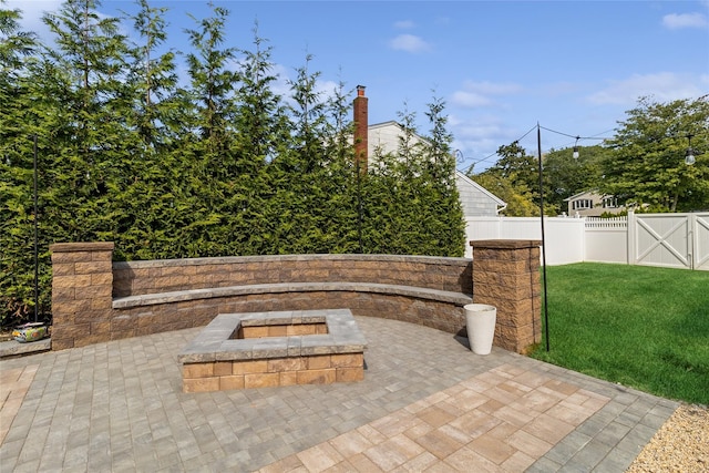 view of patio / terrace featuring a fire pit, a fenced backyard, and a gate