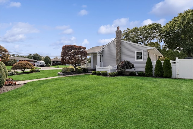 view of home's exterior with a yard, fence, and a chimney