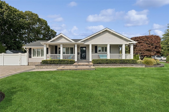 view of front of home with a front lawn, fence, and covered porch