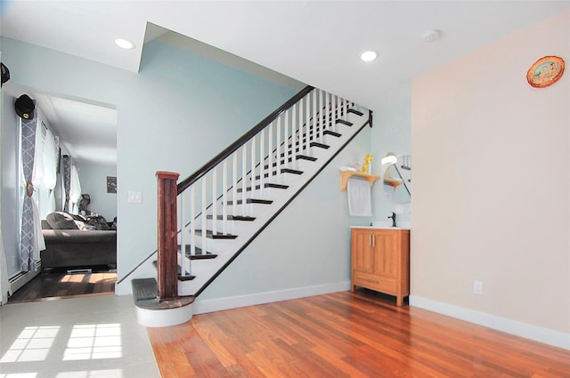 stairs with recessed lighting, wood finished floors, and baseboards