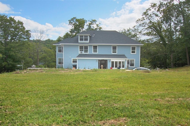 rear view of property featuring a lawn