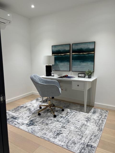 108-15 72nd Ave Unit 4D, Forest Hills, NY 11375 - office area featuring recessed lighting, baseboards, a wall unit AC, and wood finished floors