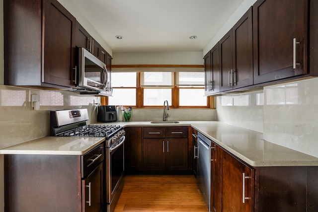 kitchen with a sink, dark brown cabinetry, and appliances with stainless steel finishes