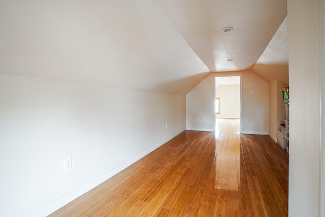 bonus room with baseboards, lofted ceiling, and hardwood / wood-style floors