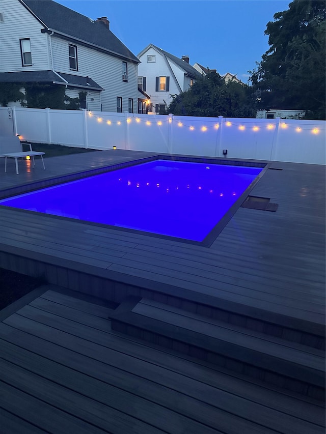 view of pool featuring a deck, a fenced in pool, and a fenced backyard