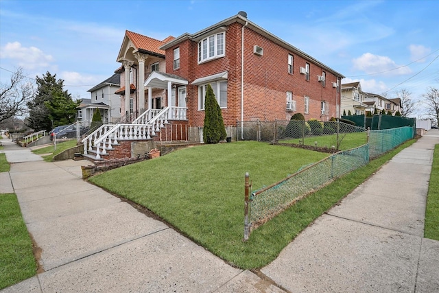 view of side of property with a yard, fence, and brick siding