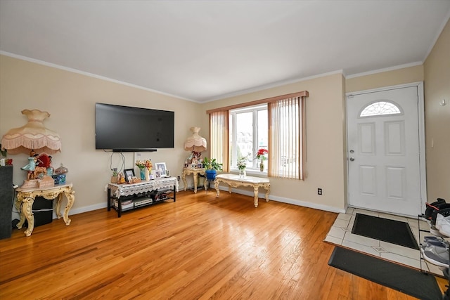 foyer featuring baseboards, light wood-style floors, and ornamental molding