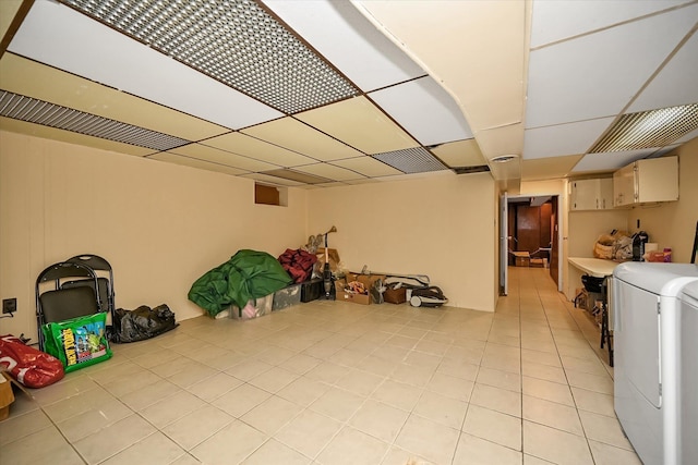 finished below grade area with light tile patterned flooring and a paneled ceiling