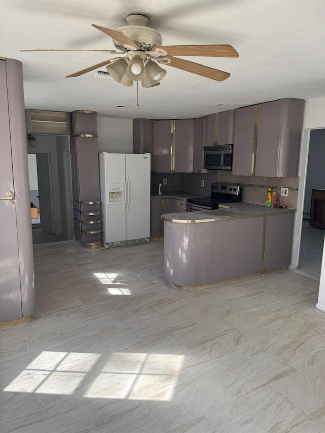 kitchen with decorative backsplash, a peninsula, ceiling fan, and stainless steel appliances