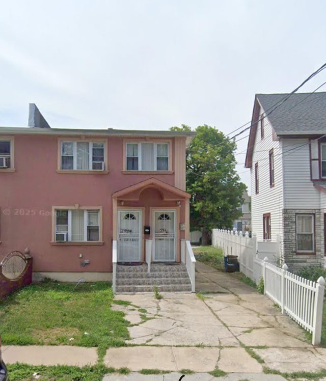 view of front of house featuring stucco siding and fence