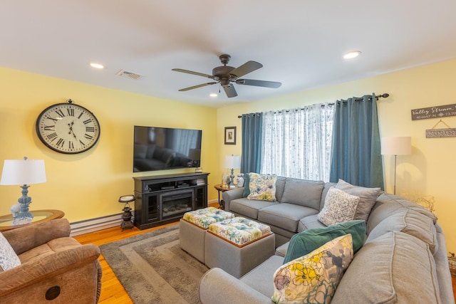 living area featuring visible vents, recessed lighting, wood finished floors, a ceiling fan, and a baseboard radiator