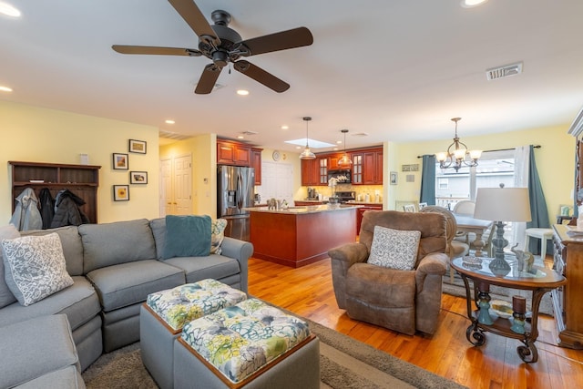 living room featuring light wood-style flooring, recessed lighting, and visible vents