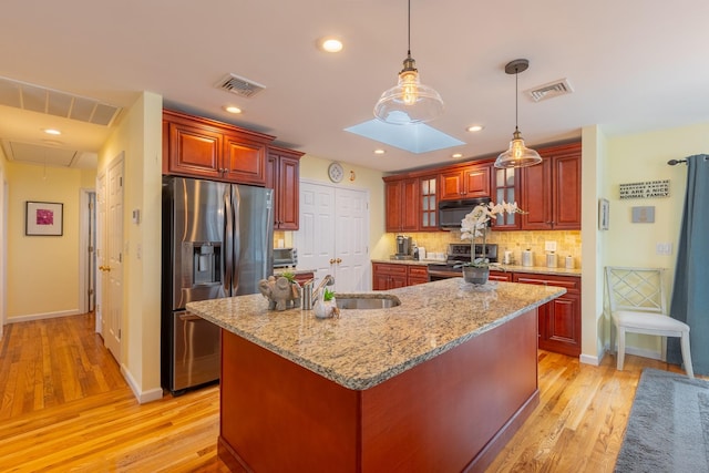 kitchen with a sink, visible vents, backsplash, and stainless steel appliances