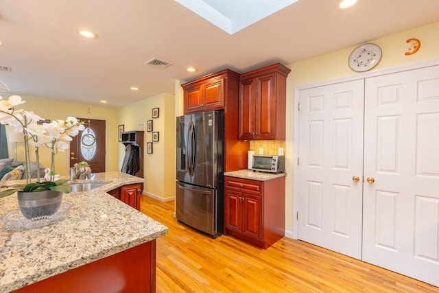 kitchen with visible vents, light wood finished floors, recessed lighting, stainless steel refrigerator with ice dispenser, and backsplash