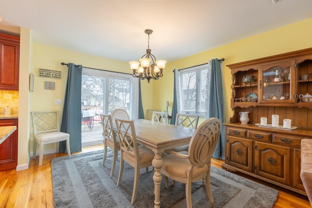 dining room with an inviting chandelier and light wood-type flooring