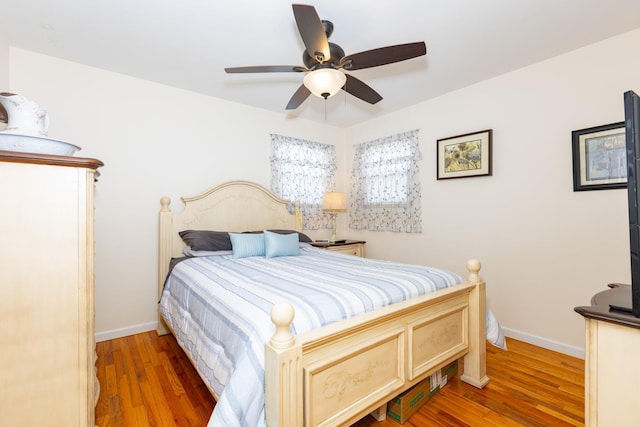 bedroom featuring light wood-style flooring, baseboards, and ceiling fan