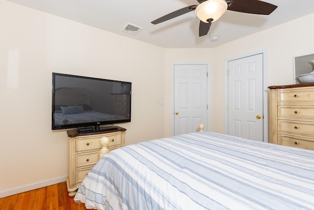 bedroom featuring visible vents, baseboards, light wood-style floors, and a ceiling fan