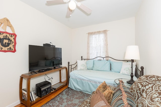 bedroom featuring baseboards, wood finished floors, and a ceiling fan