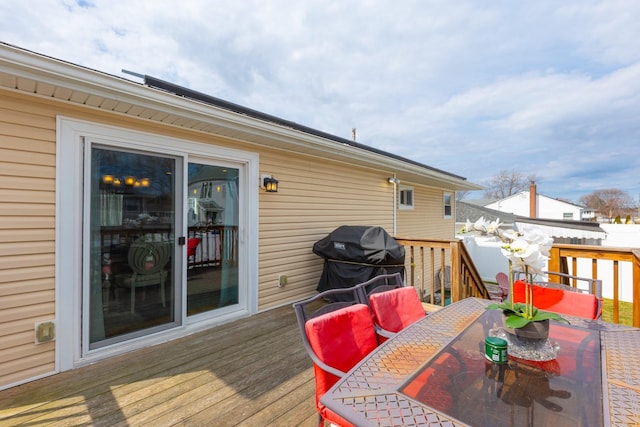 deck with outdoor dining space and grilling area