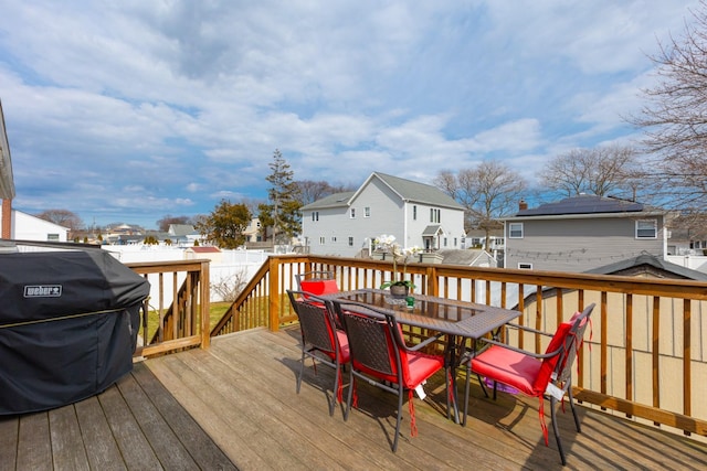 deck featuring area for grilling, outdoor dining space, a residential view, and fence