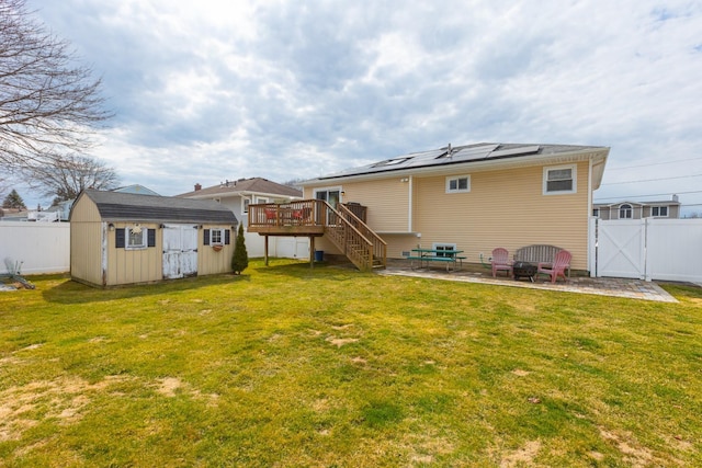 rear view of property with a patio, a shed, a yard, a fenced backyard, and an outdoor structure