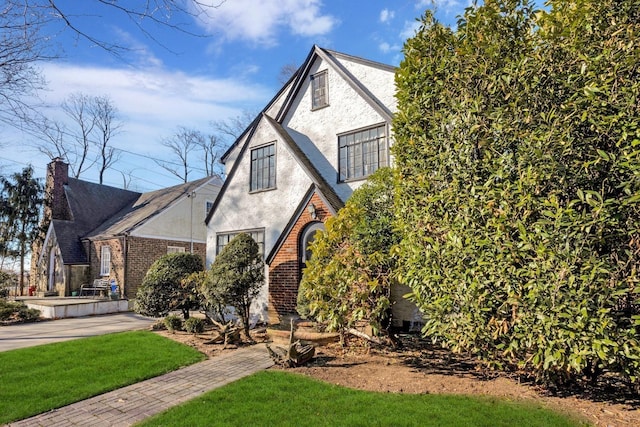 tudor-style house with brick siding and stucco siding