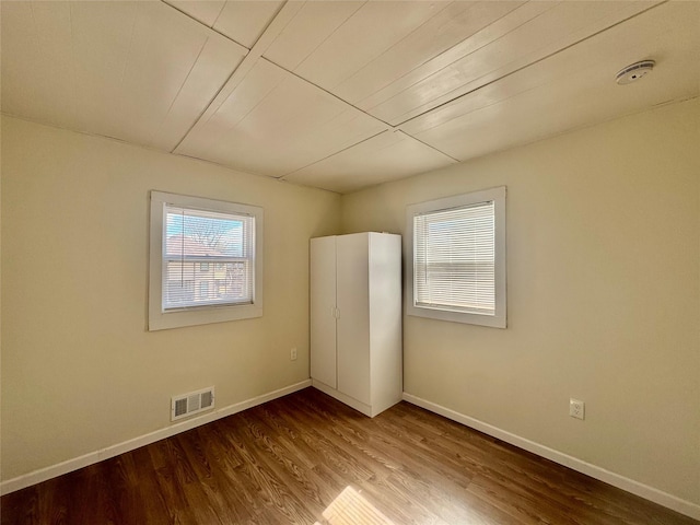 unfurnished bedroom with visible vents, baseboards, and wood finished floors