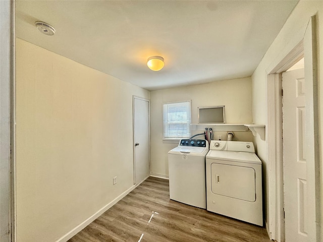 laundry room featuring laundry area, light wood-type flooring, baseboards, and separate washer and dryer