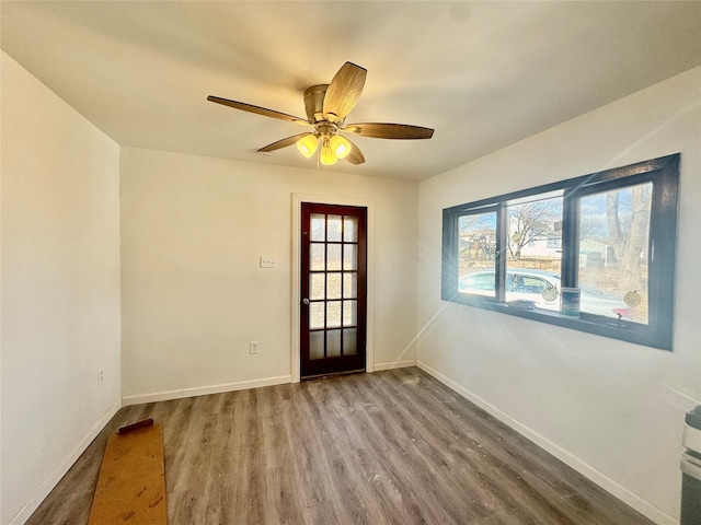 entryway featuring baseboards, wood finished floors, and a ceiling fan