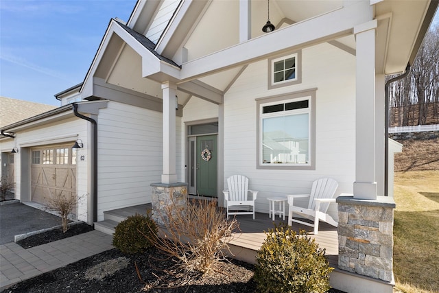 doorway to property featuring an attached garage and driveway