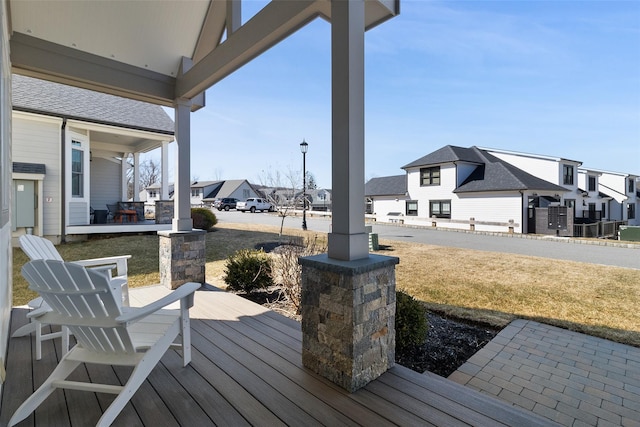 wooden terrace featuring a yard and a residential view