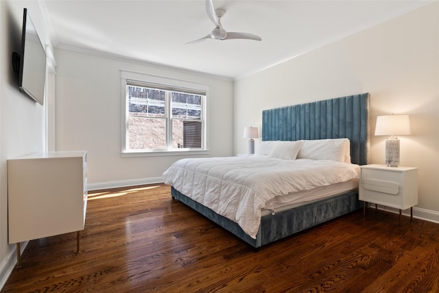 bedroom with a ceiling fan, crown molding, wood finished floors, and baseboards