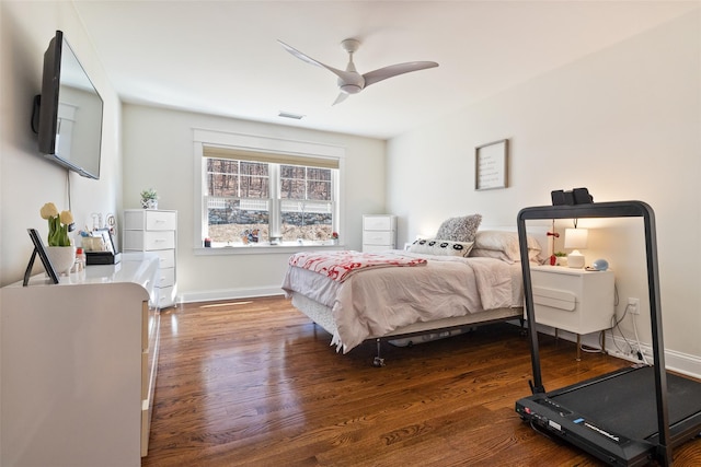 bedroom featuring visible vents, ceiling fan, baseboards, and wood finished floors