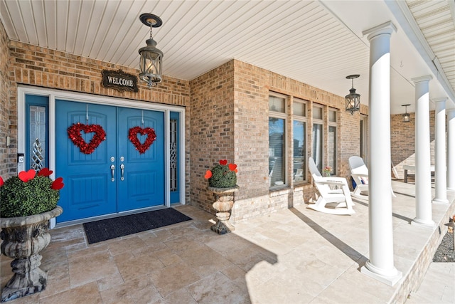 property entrance with brick siding and a porch