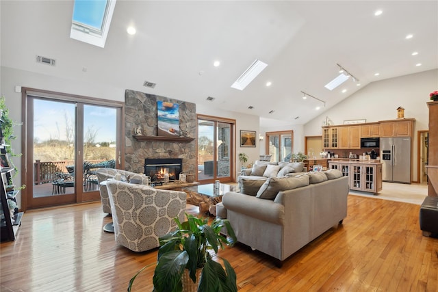 living area with a wealth of natural light, a skylight, and light wood-style floors