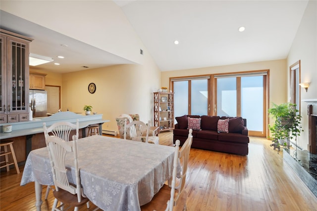 dining space with lofted ceiling, recessed lighting, light wood-type flooring, and baseboard heating