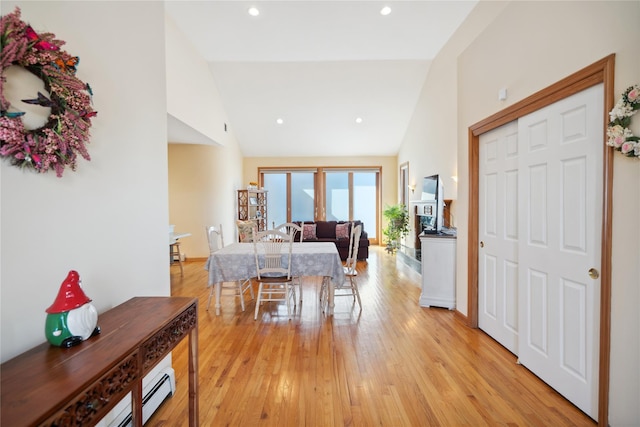 dining room with recessed lighting, light wood-type flooring, and high vaulted ceiling