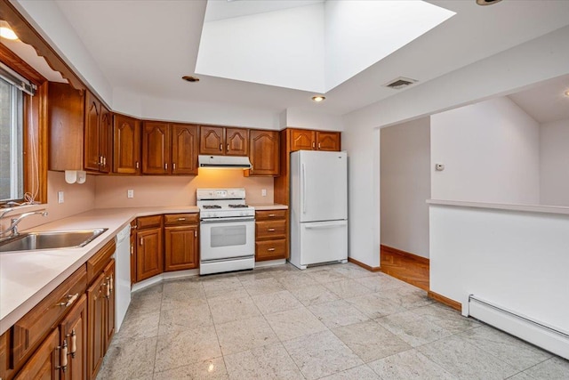 kitchen featuring visible vents, a sink, under cabinet range hood, white appliances, and a baseboard radiator