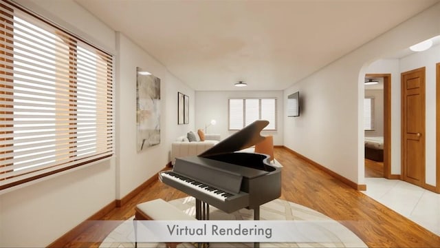 living area with light wood finished floors, arched walkways, and baseboards